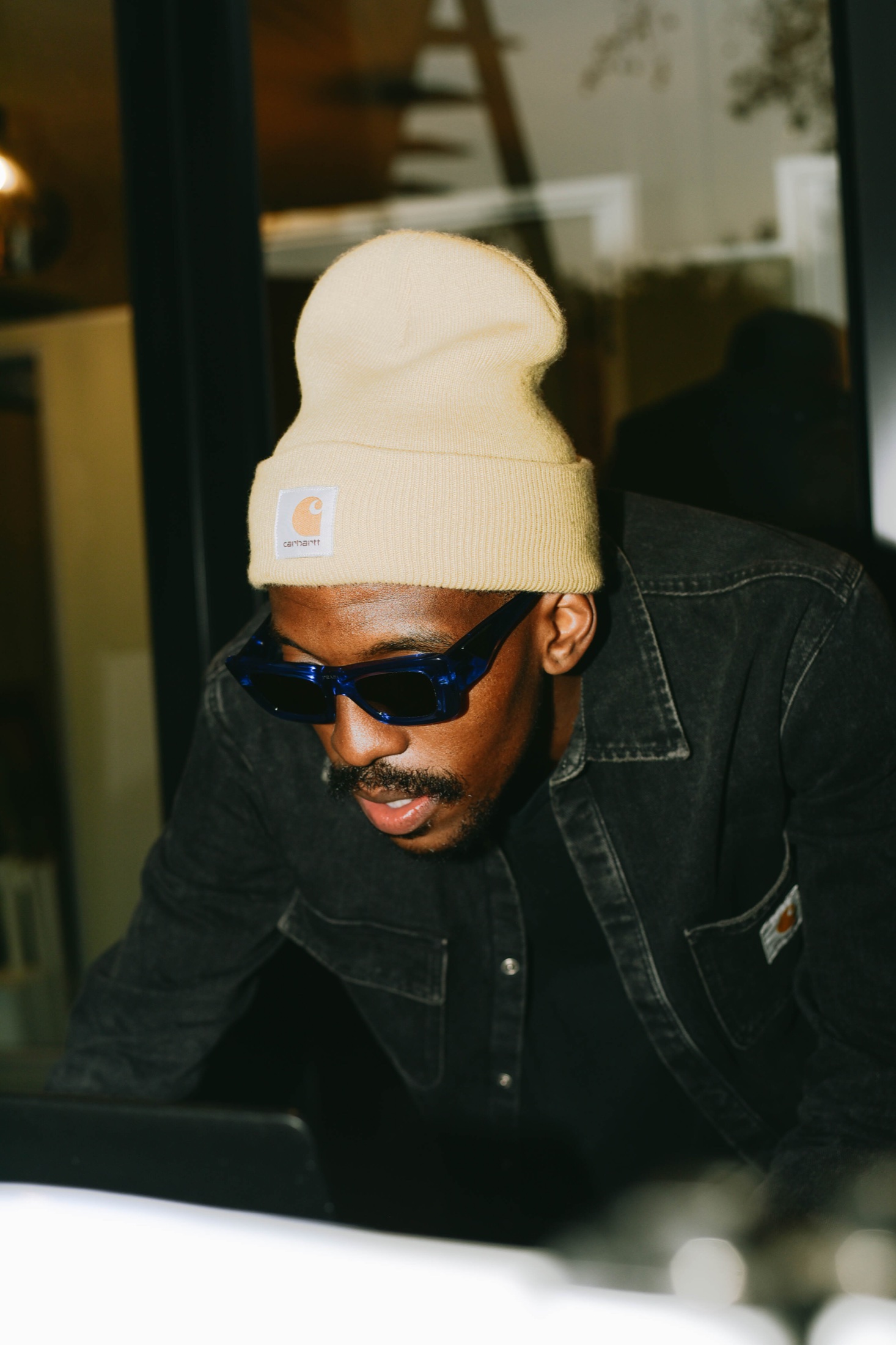 Close portrait of DOOM IT in a cream beanie and shades.