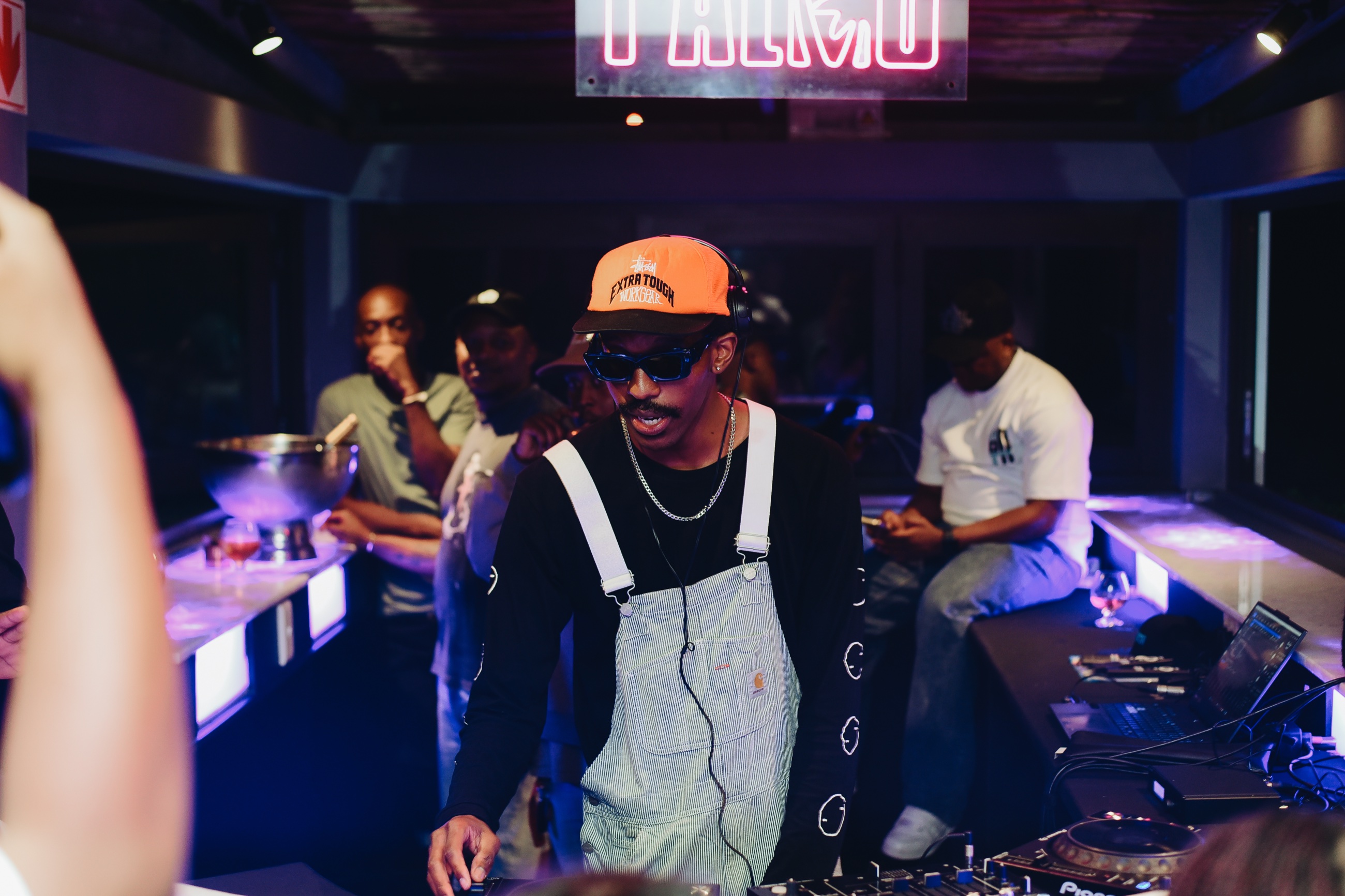 DOOM IT wearing an orange cap and goggles behind the decks at Parko.